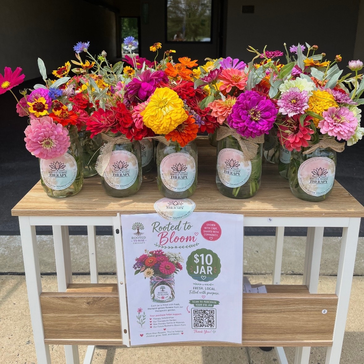 Colorful flowers in labeled jars for sale